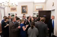 Donald Trump stands in a White House office doorway facing a group of reporters.