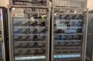 Two tall glass-fronted cabinets packed with computer hardware, with a small AlphaGo sign on the left cabinet.